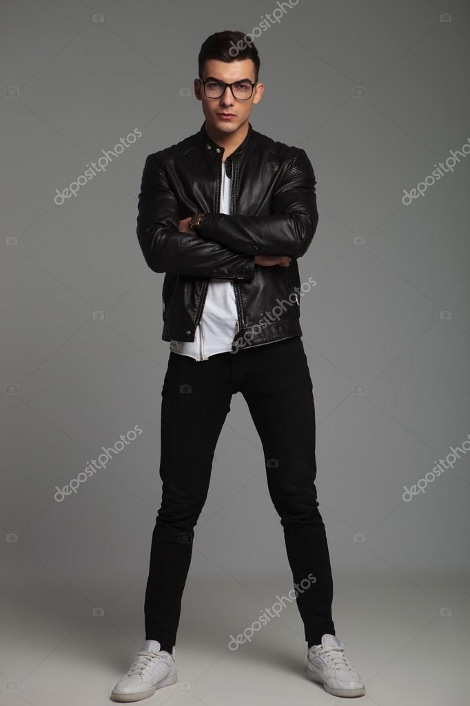 Premium Photo | Fashionable hipster man with hairstyle in stylish casual  outfit in leather jacket hoodie and jeans sits and poses near a black brick  wall on the street