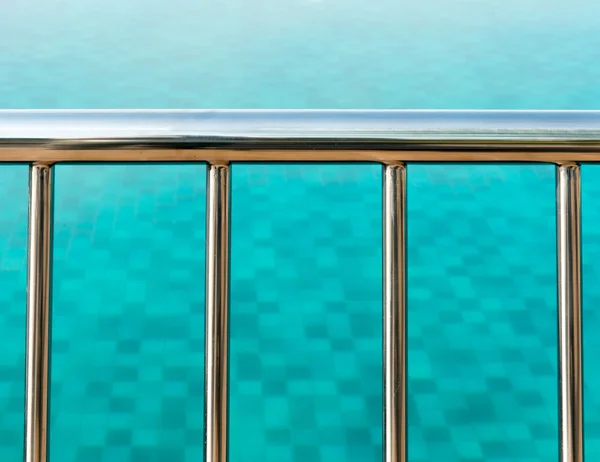 Räcken med utsikt över en tydlig pool Stockbild