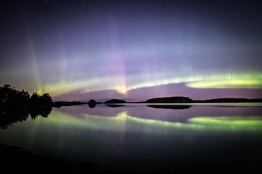 İsveç 'teki sakin göl üzerindeki kuzey ışıklarının manzarası (Aurora borealis) Farnebofjarden Milli Parkı