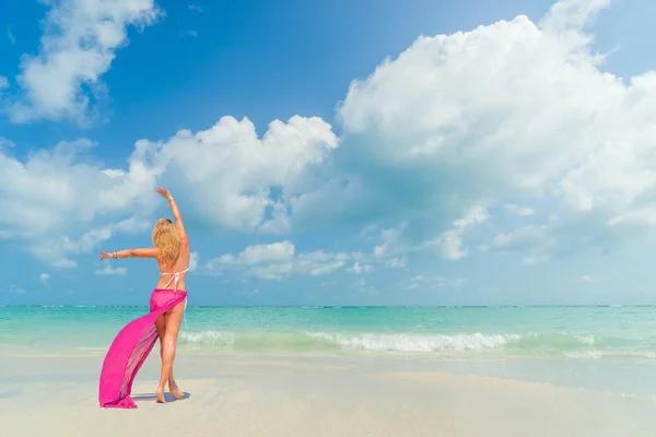 粉红色的围裙，走在沙滩上的女人 — 图库照片