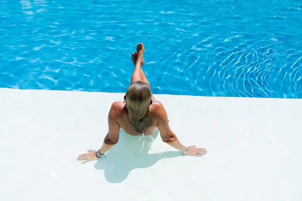 Bela mulher relaxante em uma piscina — Fotografia de Stock