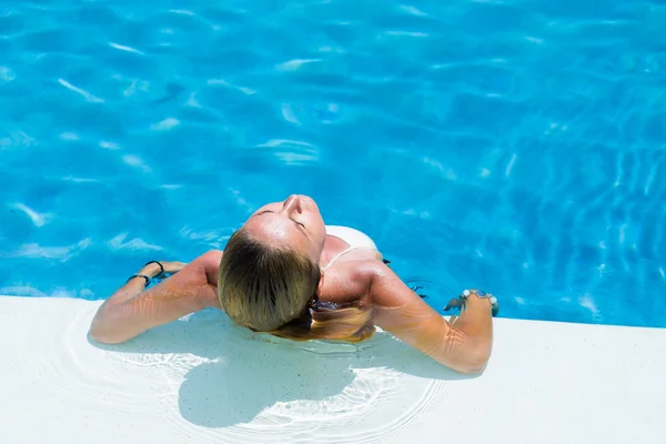 Vacker kvinna avkopplande i en pool — Stockfoto