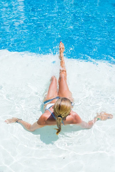 Kvinna vid poolen stänkande vatten — Stockfoto