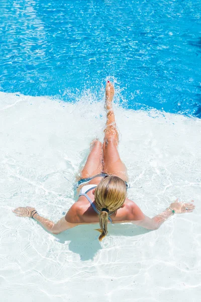 Kvinna vid poolen stänkande vatten — Stockfoto