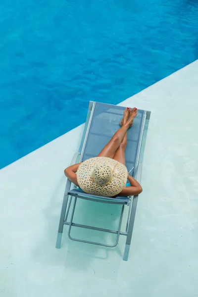 Femme profiter sur chaise longue à la piscine — Photo