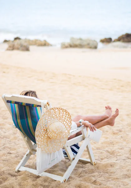 Ung kvinde slapper af på en smuk strand . - Stock-foto