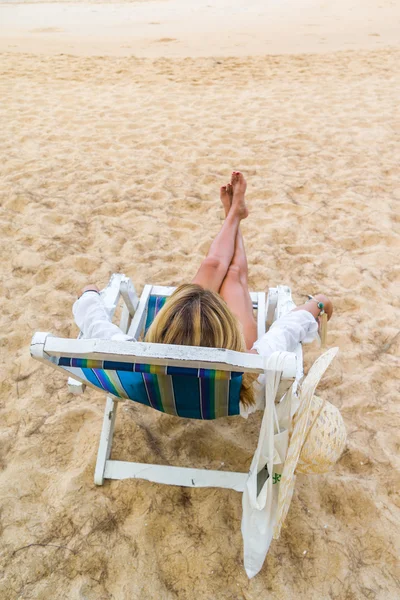 Ung kvinna avkopplande på en vacker strand. — Stockfoto