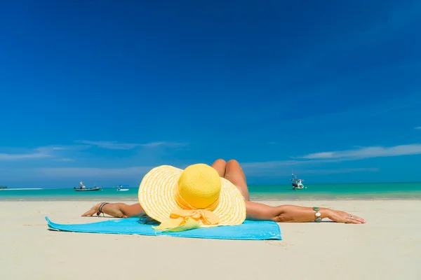 Mulher de biquíni usando um chapéu amarelo na praia tropical — Fotografia de Stock