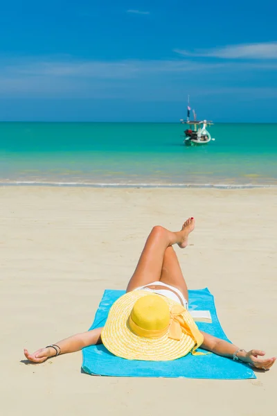 Frau im Bikini mit gelbem Hut am tropischen Strand — Stockfoto