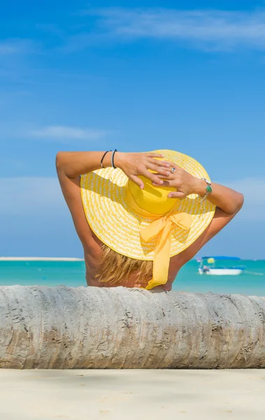 Kobieta w bikini w żółtym kapeluszu na tropikalnej plaży — Zdjęcie stockowe