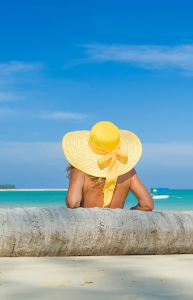 Kobieta w bikini w żółtym kapeluszu na tropikalnej plaży — Zdjęcie stockowe