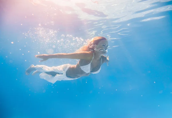 Vrouw onder water in het zwembad — Stockfoto