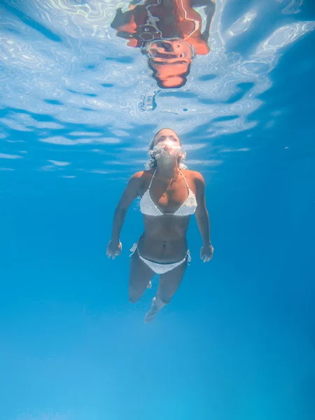 Vrouw onder water in het zwembad — Stockfoto