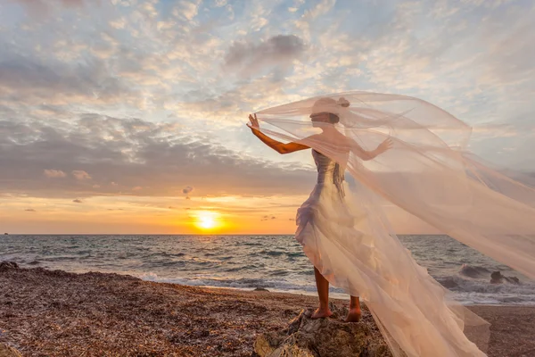 Novia posando mostrando su vestido de novia en la playa — Foto de Stock