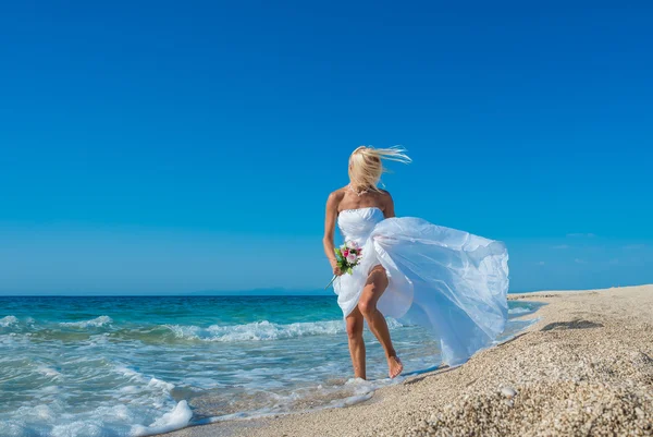 Красивая молодая невеста гуляет по пляжу — стоковое фото