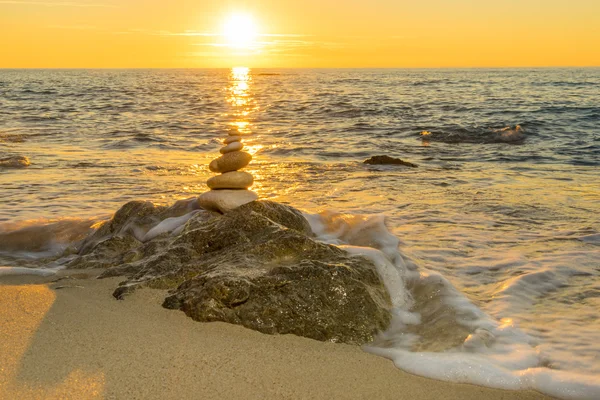 Stones pyramid on sand symbolizing zen, harmony, balance. Ocean — Stock Photo, Image