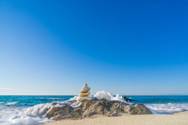 Stones pyramid on sand symbolizing zen, harmony, balance. Ocean — Stock Photo, Image