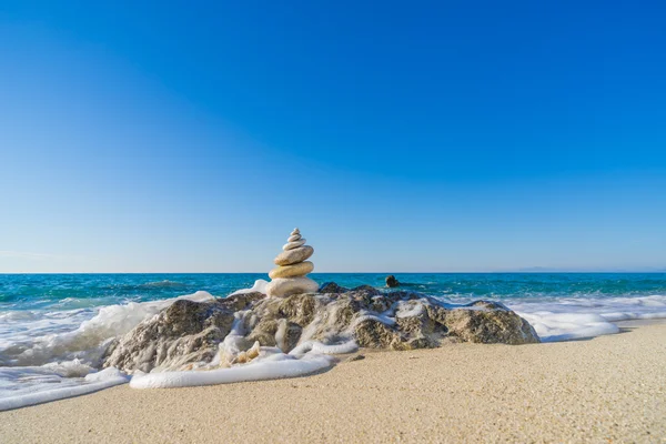 Steinpyramide auf Sand symbolisiert Zen, Harmonie, Gleichgewicht. Ozean — Stockfoto
