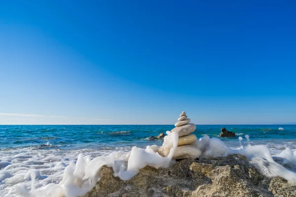 Stenen piramide op zand symboliseert zen, harmonie, balans. Oceaan — Stockfoto