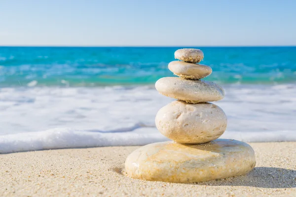 Steinpyramide auf Sand symbolisiert Zen, Harmonie, Gleichgewicht. Ozean — Stockfoto