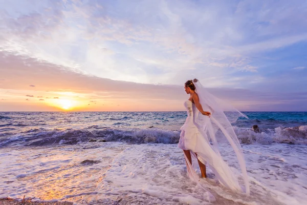 摆在海滩上展示她的婚纱的新娘 — 图库照片