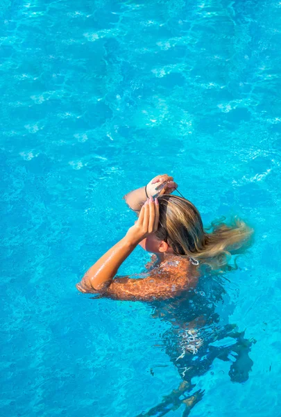 Uma menina está relaxando em uma piscina — Fotografia de Stock