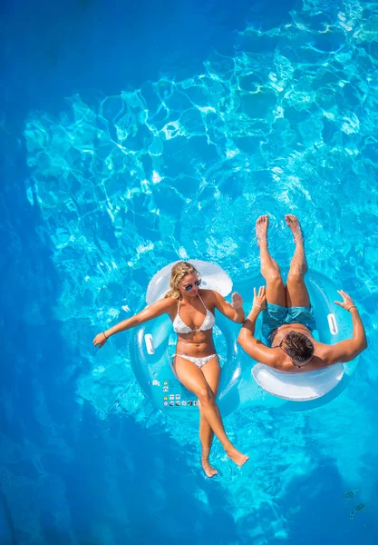 Happy couple on lilos in the pool — Stock Photo, Image