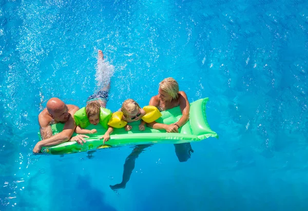 Familia fuera de relajarse en la piscina — Foto de Stock