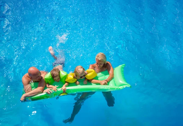 Familia fuera de relajarse en la piscina — Foto de Stock