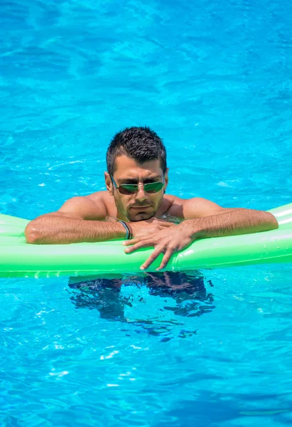 Man relaxing on the air bed in the swimming pool. — Stock Photo, Image