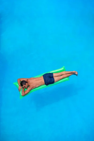 Hombre relajándose en la cama de aire en la piscina . —  Fotos de Stock