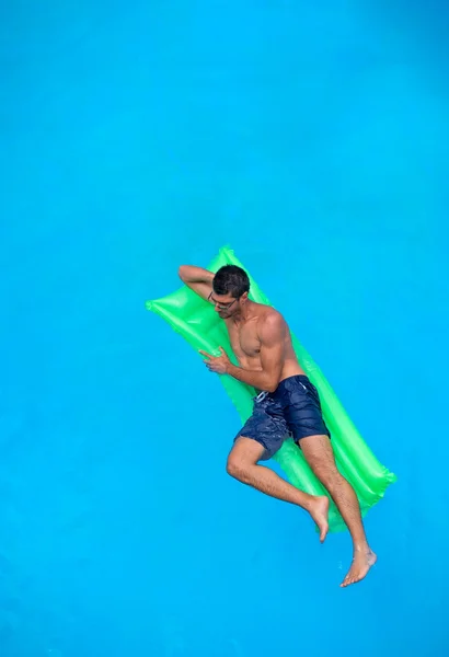 Man ontspannen op het bed van de lucht in het zwembad. — Stockfoto