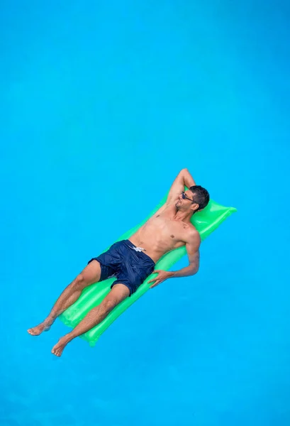 Man relaxing on the air bed in the swimming pool. — Stock Photo, Image