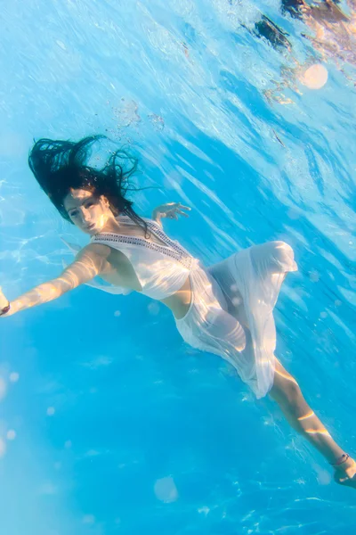 Mulher em um vestido branco subaquático na piscina — Fotografia de Stock