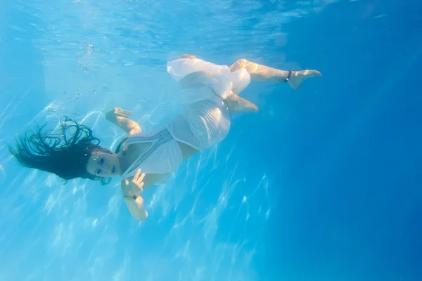 Kobieta w białej sukni pod wodą w basenie — Zdjęcie stockowe