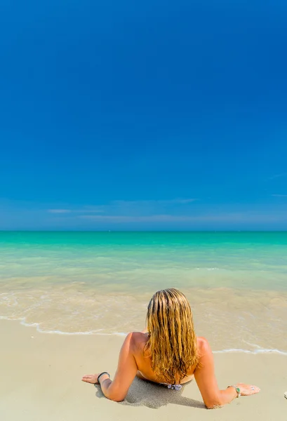 Kvinna i baddräkt avkopplande på stranden — Stockfoto