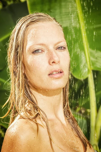 Vrouw in tropische douche — Stockfoto