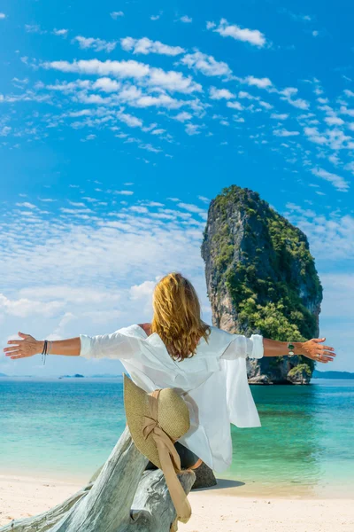 Donna sulla spiaggia seduta su un albero — Foto Stock