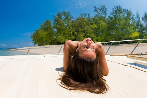 Mooie jonge vrouw op een speedboot op het tropische strand — Stockfoto