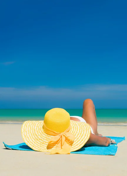 Подходит женщина в солнцезащитной шляпе и бикини на пляже — стоковое фото