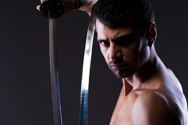 Jovem sem camisa posando com katana — Fotografia de Stock