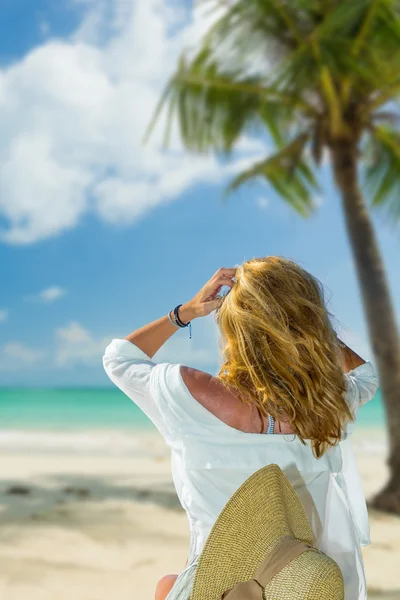 Frau im Bikini mit Sonnenhut am Strand — Stockfoto