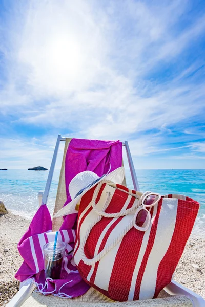 Beach with deck chair, towel, bag, hat — Stock Photo, Image