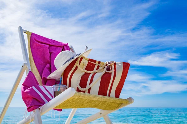 Beach with deck chair, towel, bag, hat — Stock Photo, Image