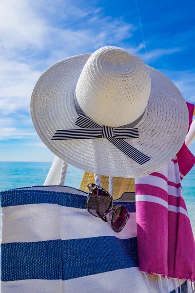 Пляж с шезлонгом, полотенце, сумка, шляпа — стоковое фото