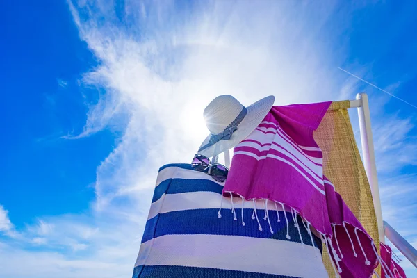 Beach with deck chair, towel, bag, hat — Stock Photo, Image