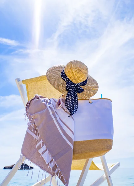 Пляж з шезлонгом, рушником, сумкою, капелюхом — стокове фото