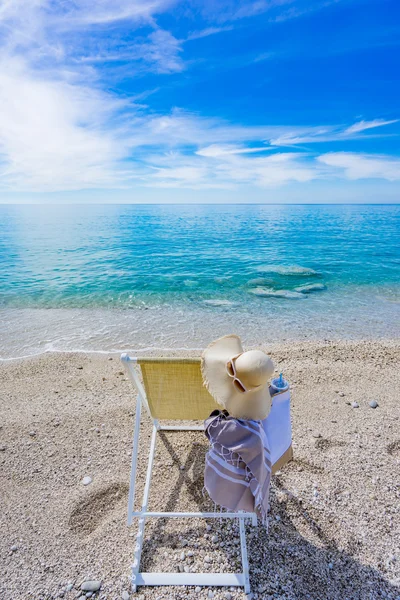 Beach with deck chair, towel, bag, hat — Stock Photo, Image