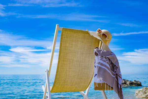 Beach with deck chair, towel, bag, hat — Stock Photo, Image