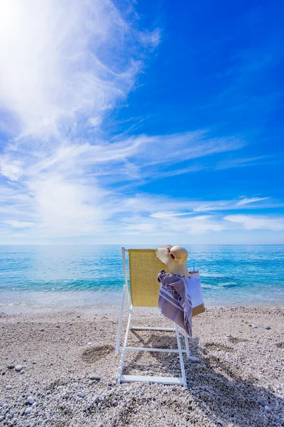 Strand mit Liegestuhl, Handtuch, Tasche, Hut — Stockfoto